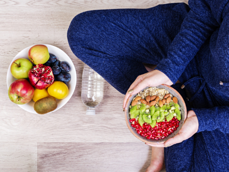 Fitness and healthy lifestyle concept. Female is resting and eating a healthy oatmeal after a workout. Top view.
